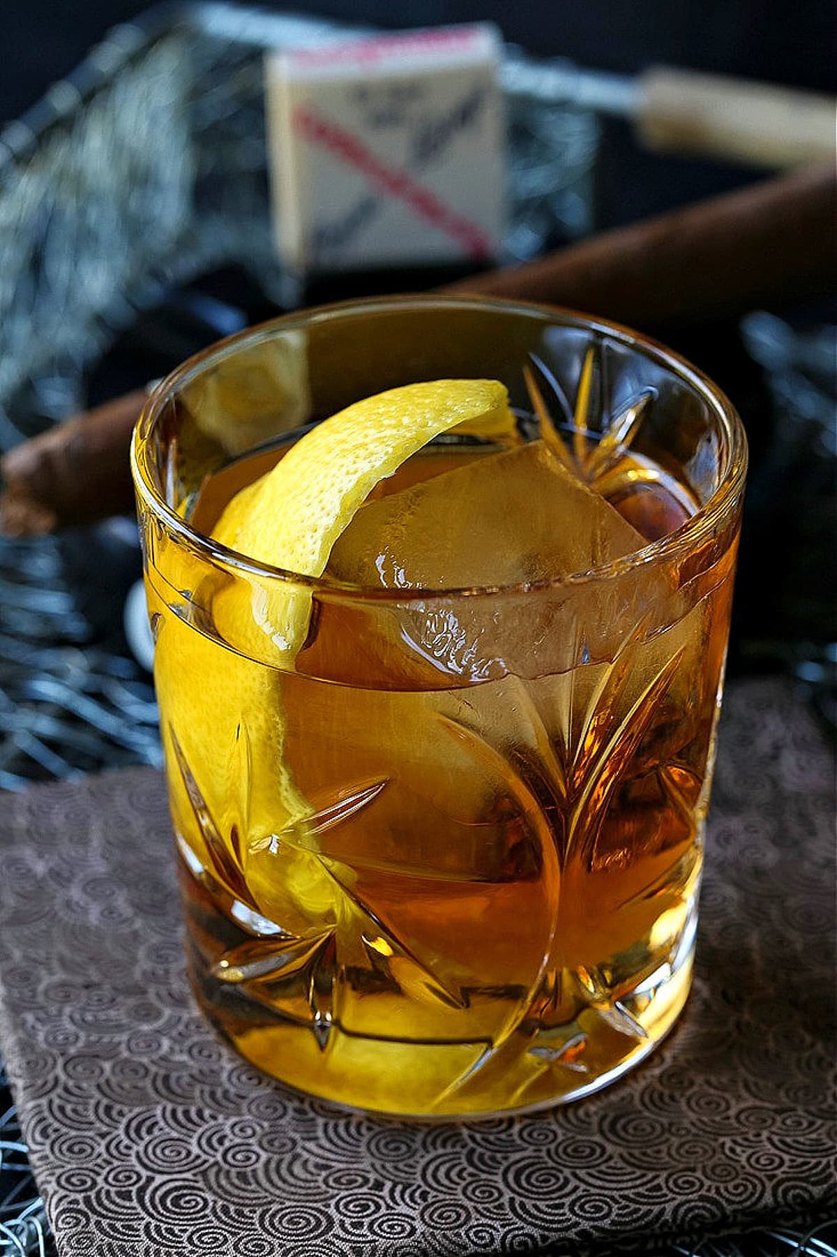 bourbon cocktail with large lemon peel garnish and ice