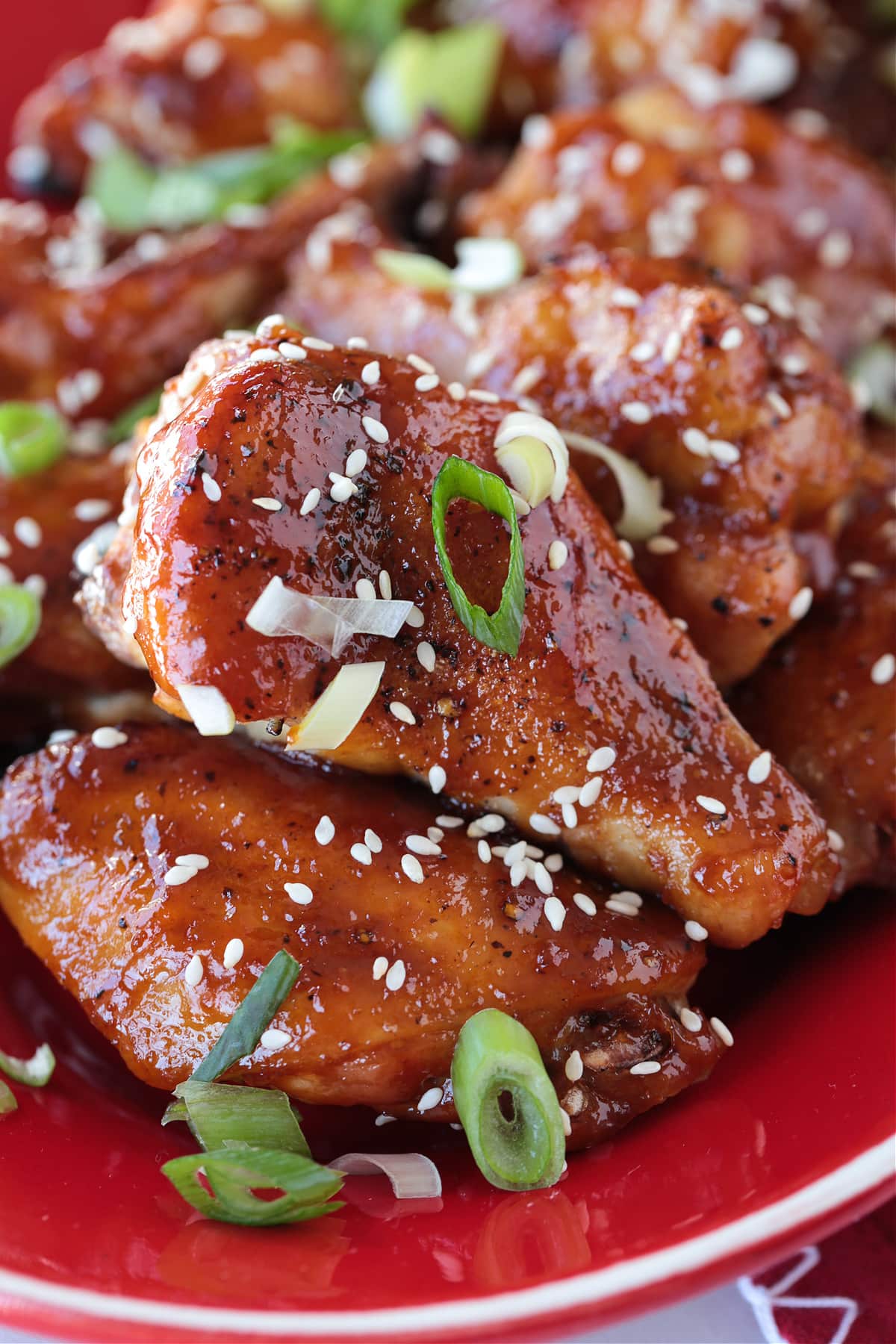These Asian Chicken Wings are oven baked until tender, with a sticky, sweet addicting sauce. Perfect for appetizers or a fun dinner! asian chicken wings with sesame seeds and scallions