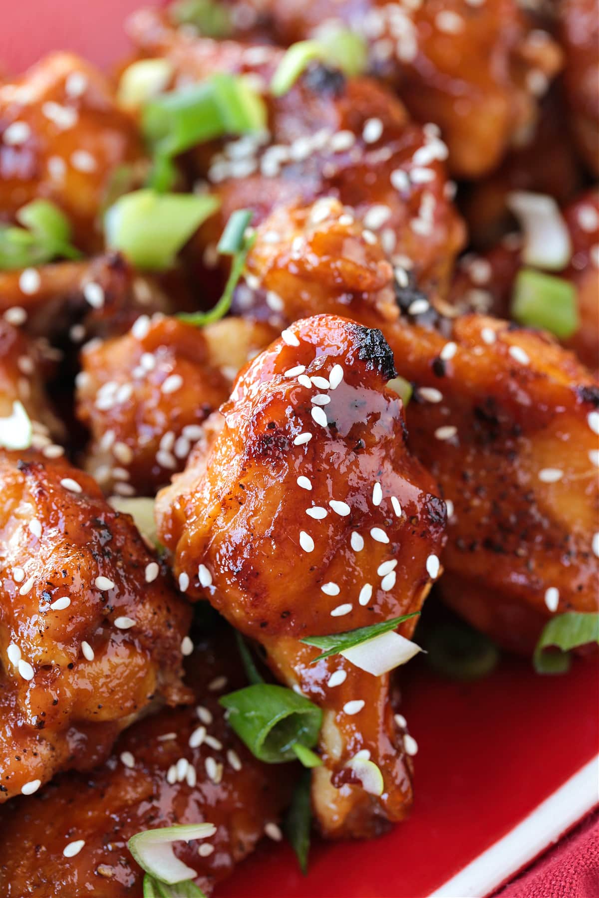 baked chicken wings with sauce on a red platter