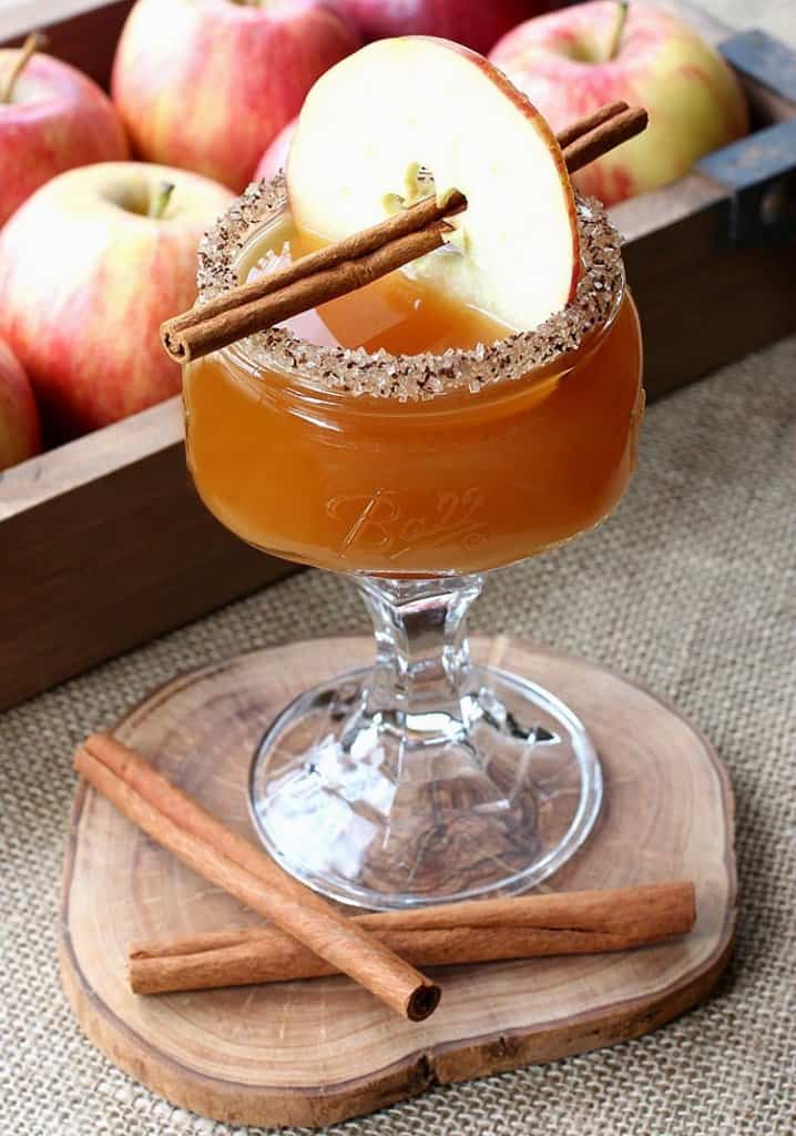 apple cider martini with an apple slice and cinnamon stick for garnish
