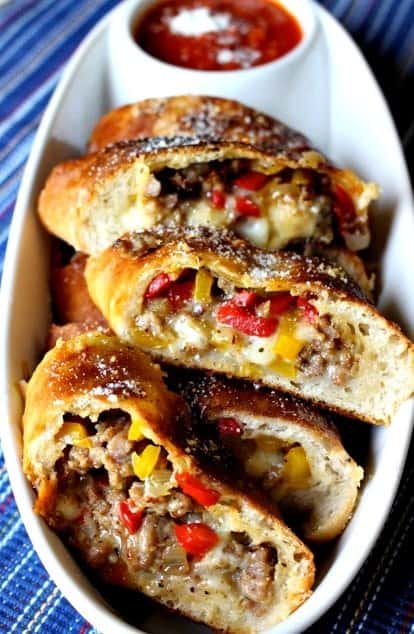 sausage and pepper stuffed bread in a white dish