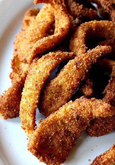 Golden fried calamari strips on a white plate