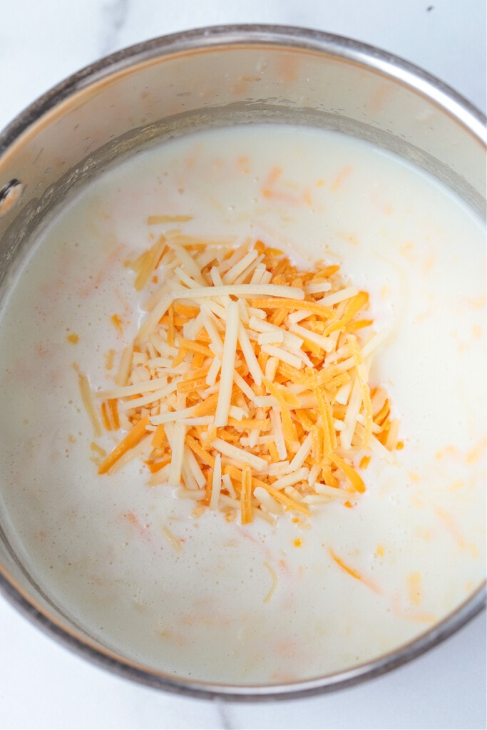 A Kentucky Hot Brown Sandwich is a delicious way to use leftover turkey. Baked with slices of tomato and bacon smothered in a cheesy sauce! shredded cheddar cheese in a pot with milk to make Mornay sauce