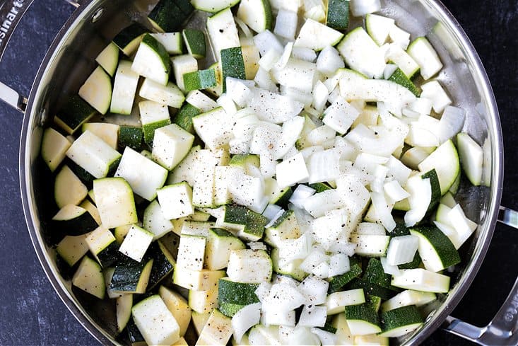 Raw zucchini and onions in a skillet for making zucchini pasta sauce