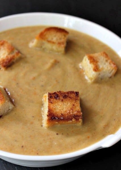 Roasted zucchini soup with croutons in a white bowl