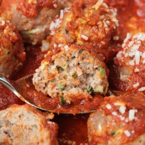a cut turkey zucchini meatball on a spoon with sauce