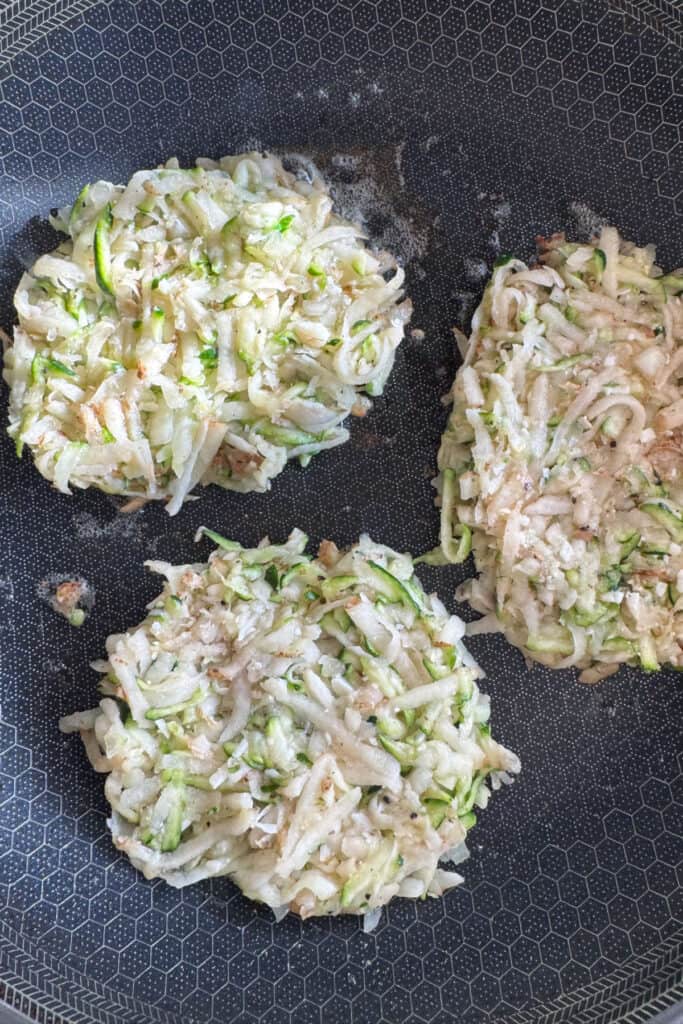 grated potato and zucchini in a skillet