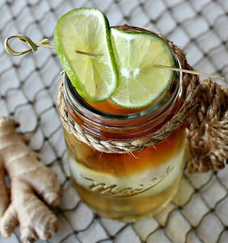 Top view of a Dark and Stormy drink in a mason cup with limes