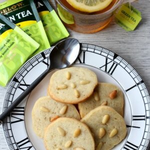 pignoli cookies on plate with tea