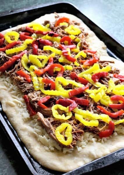 This Italian Beef Pizza has all the flavors of an Italian Beef Sandwich baked on a pizza! A fun recipe to serve at game days and parties! peppers and beef on pizza