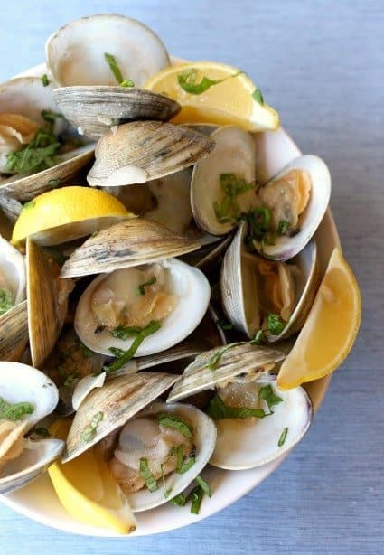 Steamed clams with lemons in a bowl