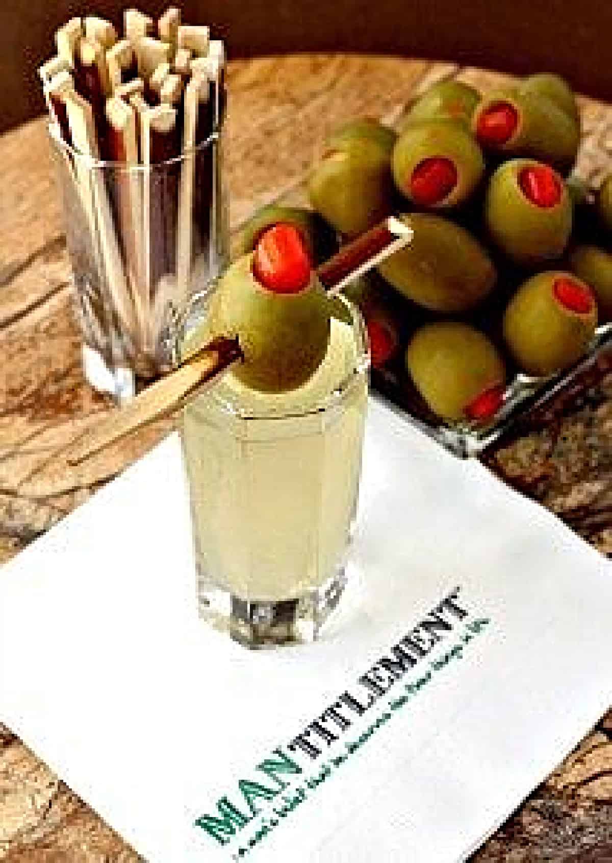 vodka shot with olive garnish on napkin