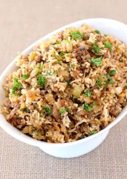 Our Easy Dirty Rice Recipe is done in about 30 minutes! A hearty, classic rice recipe that can be served as a side or even a main course! dirty rice in a bowl with parsley on top