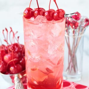 a dirty shirley cocktail with cherries on top