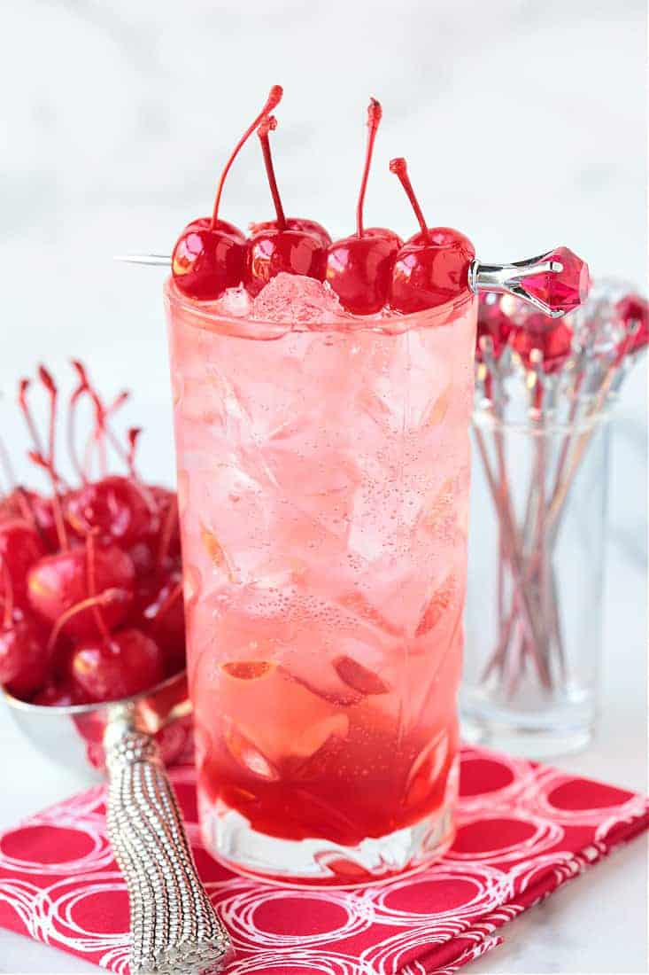 a dirty shirley cocktail with cherries on top