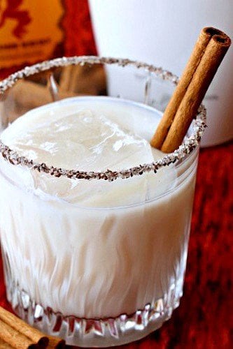 creamy cocktail with a cinnamon stick close up in glass