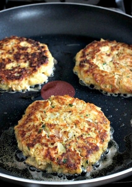 Salmon burgers being cooked in a pan