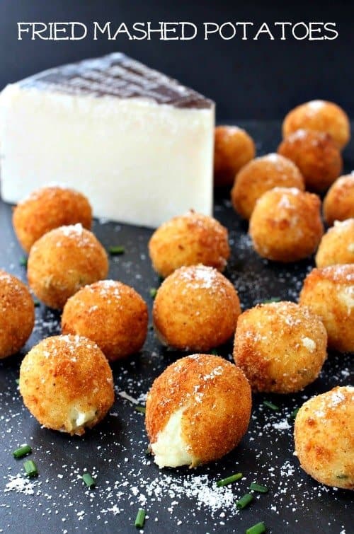 fried mashed potatoes on a black board with parmesan cheese