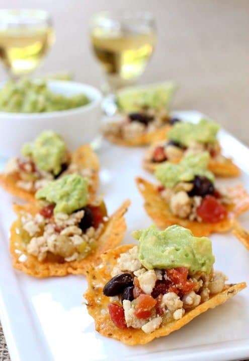 Cheese crisps with nacho topping on top on a white plate