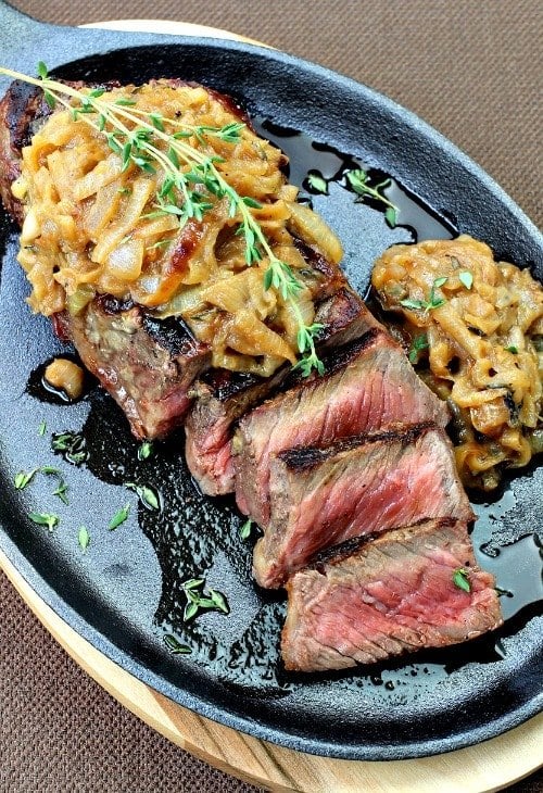 Strip Steak with onions on a cast iron plate