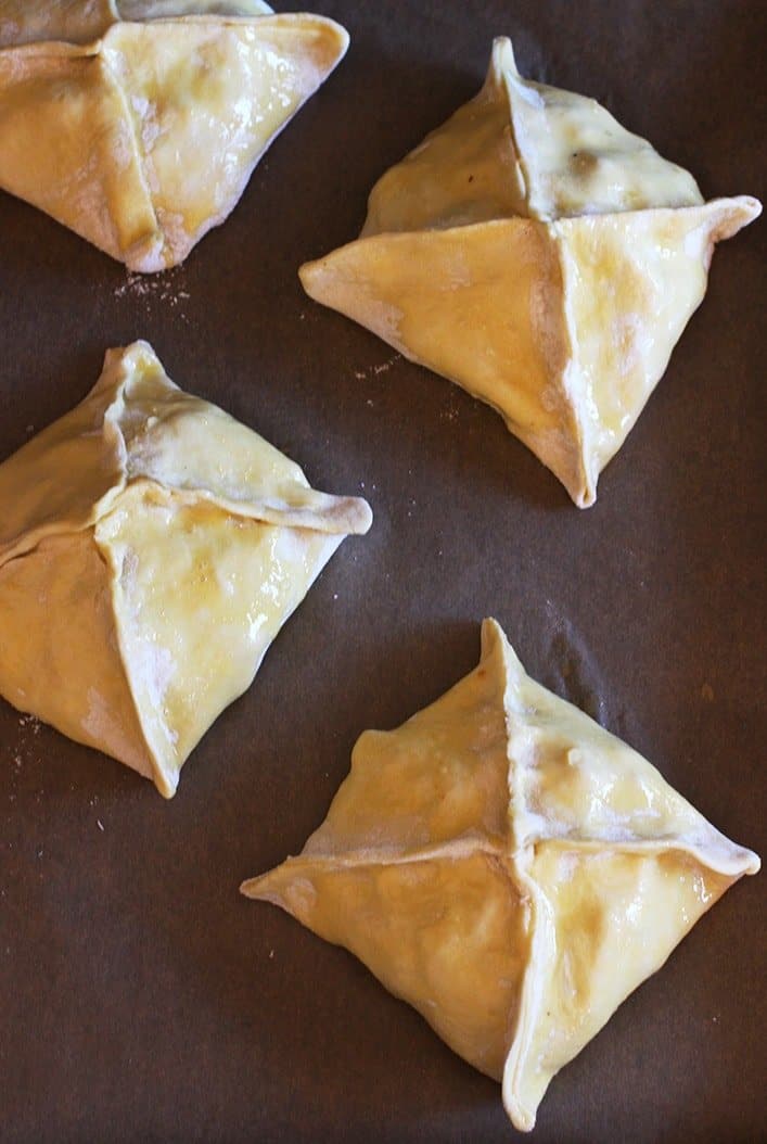 Green Chile Chicken Hand Pies are filled with a cheesy chicken filling that has just the right amount of heat! These are great for appetizers or dinner! Green Chile Chicken Hand Pies on baking sheet