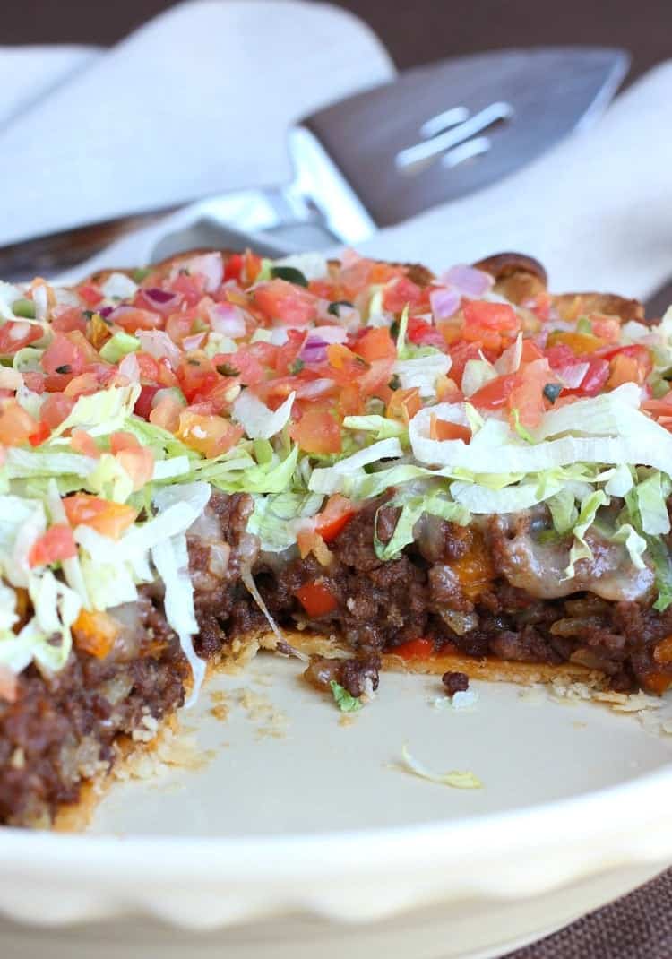 A Loaded Taco Pie with a slice missing so you can see the beef and taco toppings