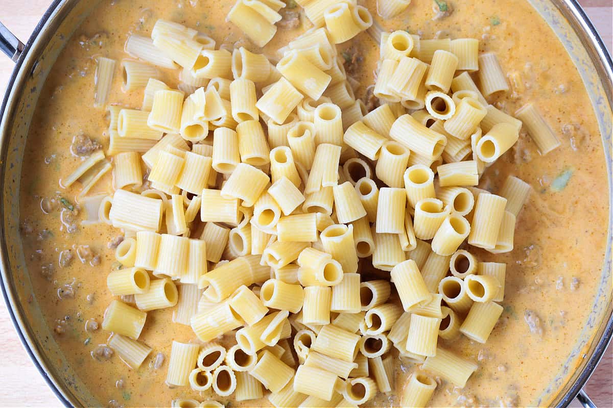 rigatoni in a skillet with pumpkin cream sauce