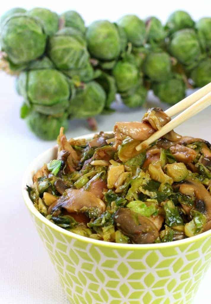 Asian style Chicken and Brussels Sprouts in a bowl with chopsticks taking some out