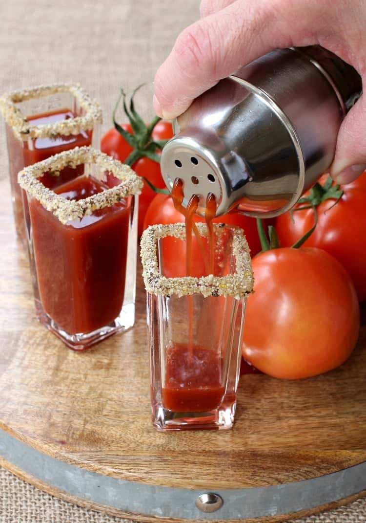 These Winey Mary Shooters are a fun twist on a Bloody Mary! A Bloody Mary shot made with red wine that's perfect for game days and brunch! cocktail being strained into a shot glass
