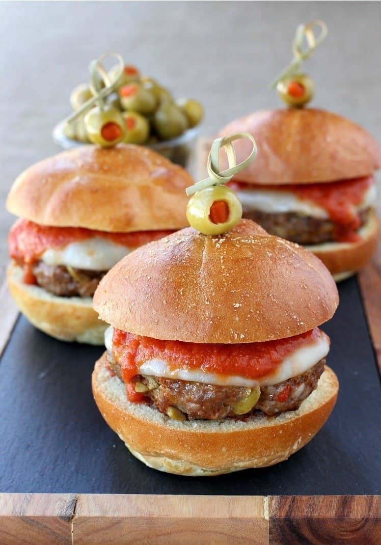 Picadillo Sausage Sliders are a fun and tasty party recipe! Italian sausage patties made with chopped olives and topped with sauce and cheese. sausage-picadillo-sliders-featured