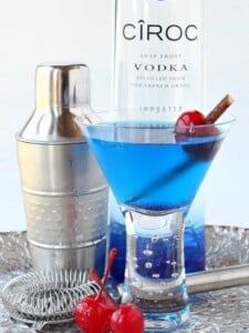 blue martini in glass with cherries
