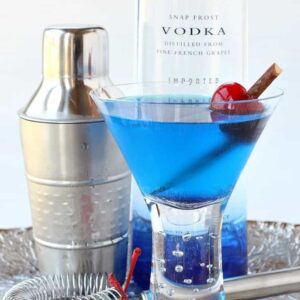 blue martini in glass with cherries