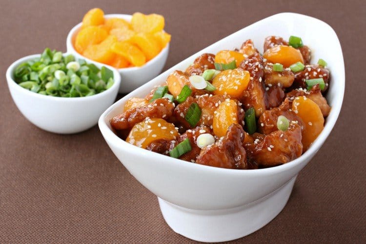 mandarin orange chicken in a bowl with sides