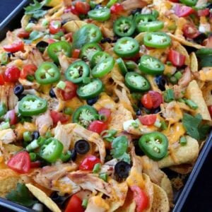 chicken nachos on a pan with toppings