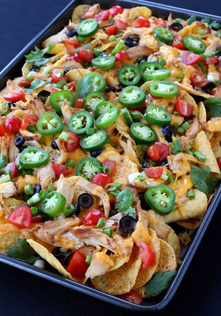 chicken nachos on a pan with toppings