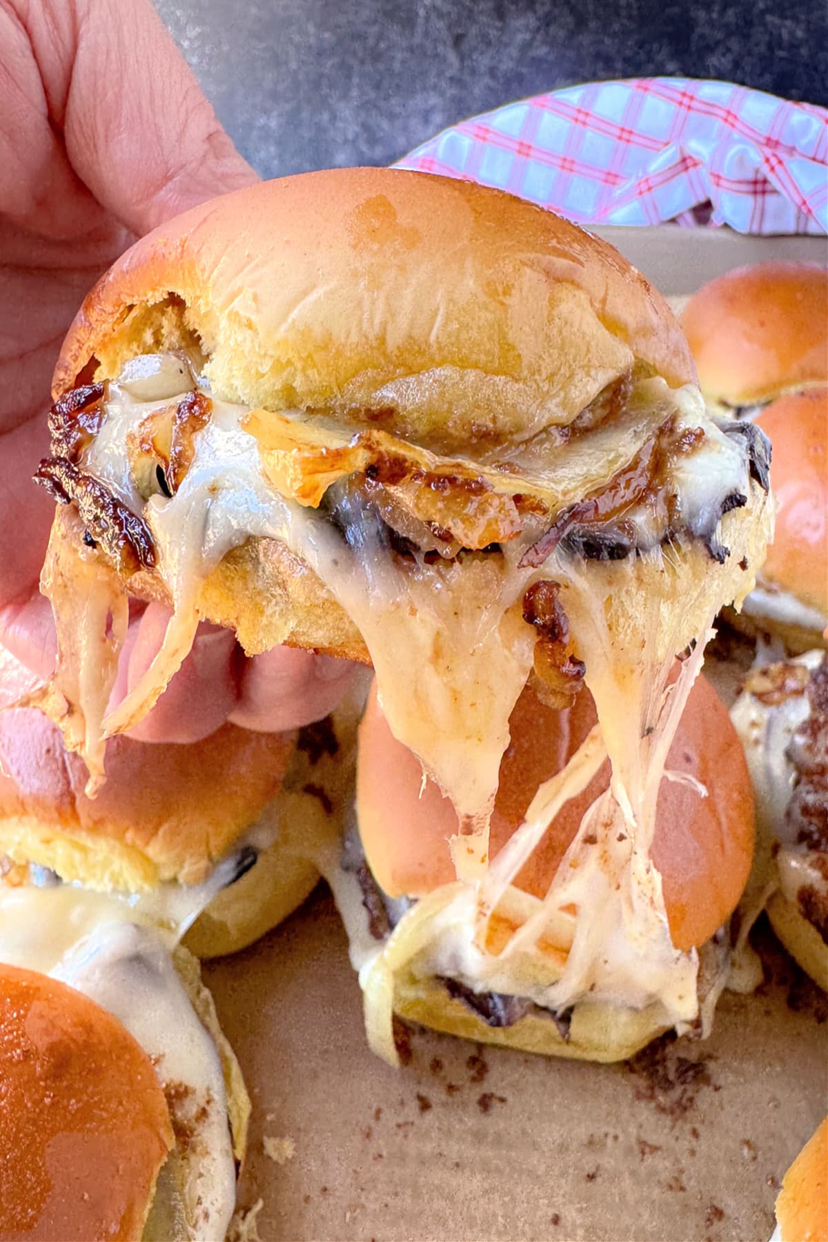 Our French Dip Sliders have a secret sauce that sets them apart from the rest. Beefy, cheesy comfort food perfect for parties and game days! french dip slider with cheese pull