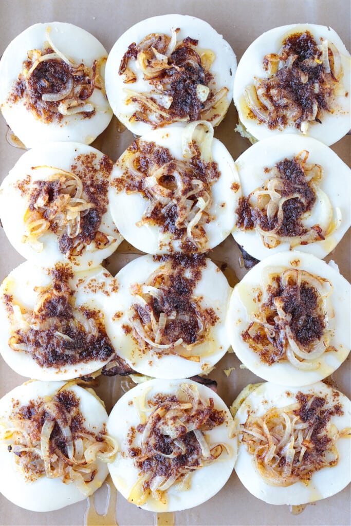 Our French Dip Sliders have a secret sauce that sets them apart from the rest. Beefy, cheesy comfort food perfect for parties and game days! open faced sliders with cheese and onions