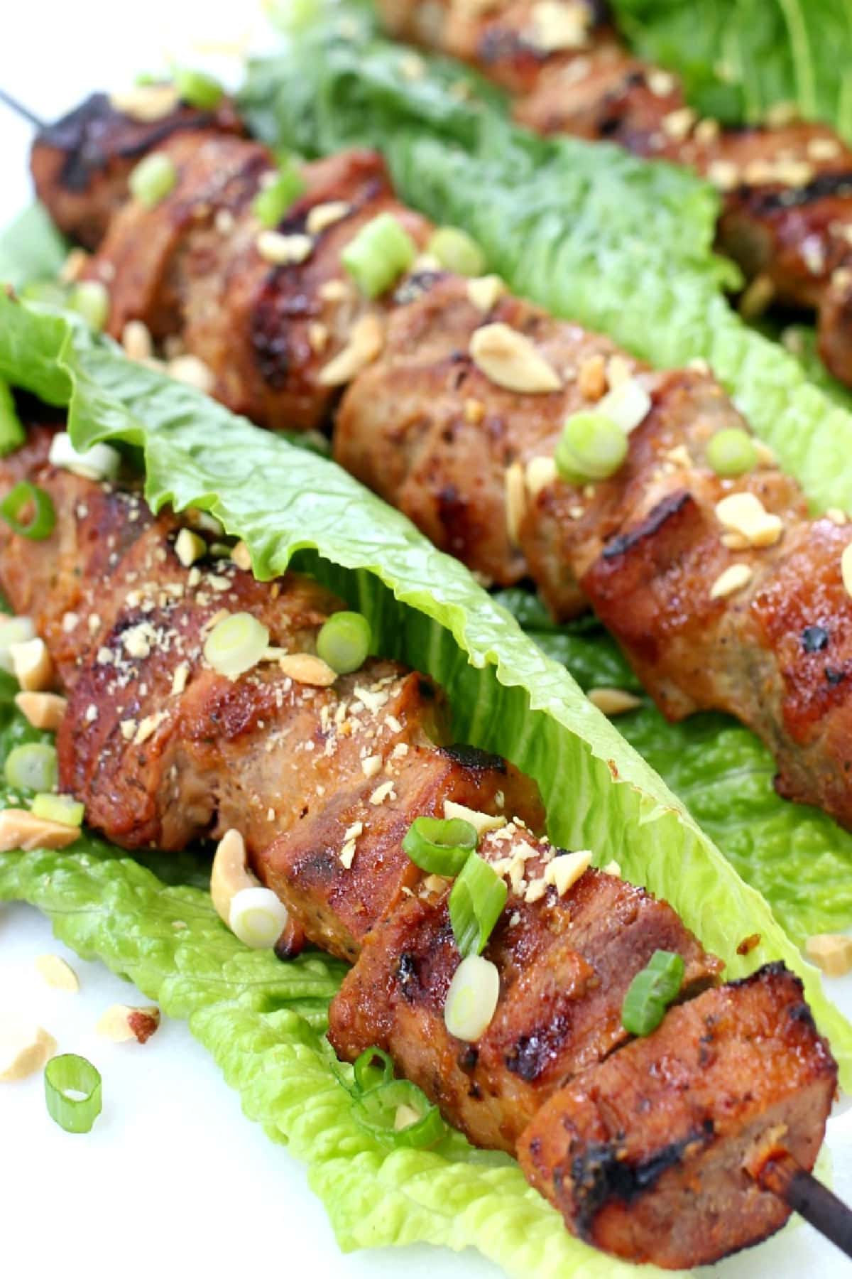 close up of pork kabobs in lettuce leaves