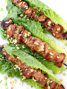 pork kabobs in lettuce leaves with chopped peanuts