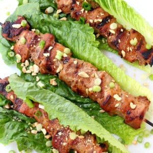 pork kabobs in lettuce leaves with chopped peanuts