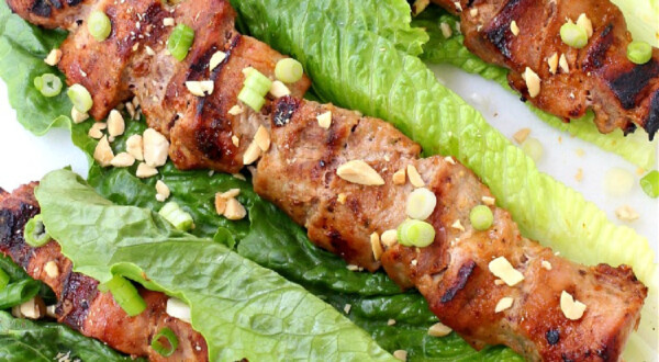 pork kabobs in lettuce leaves with chopped peanuts
