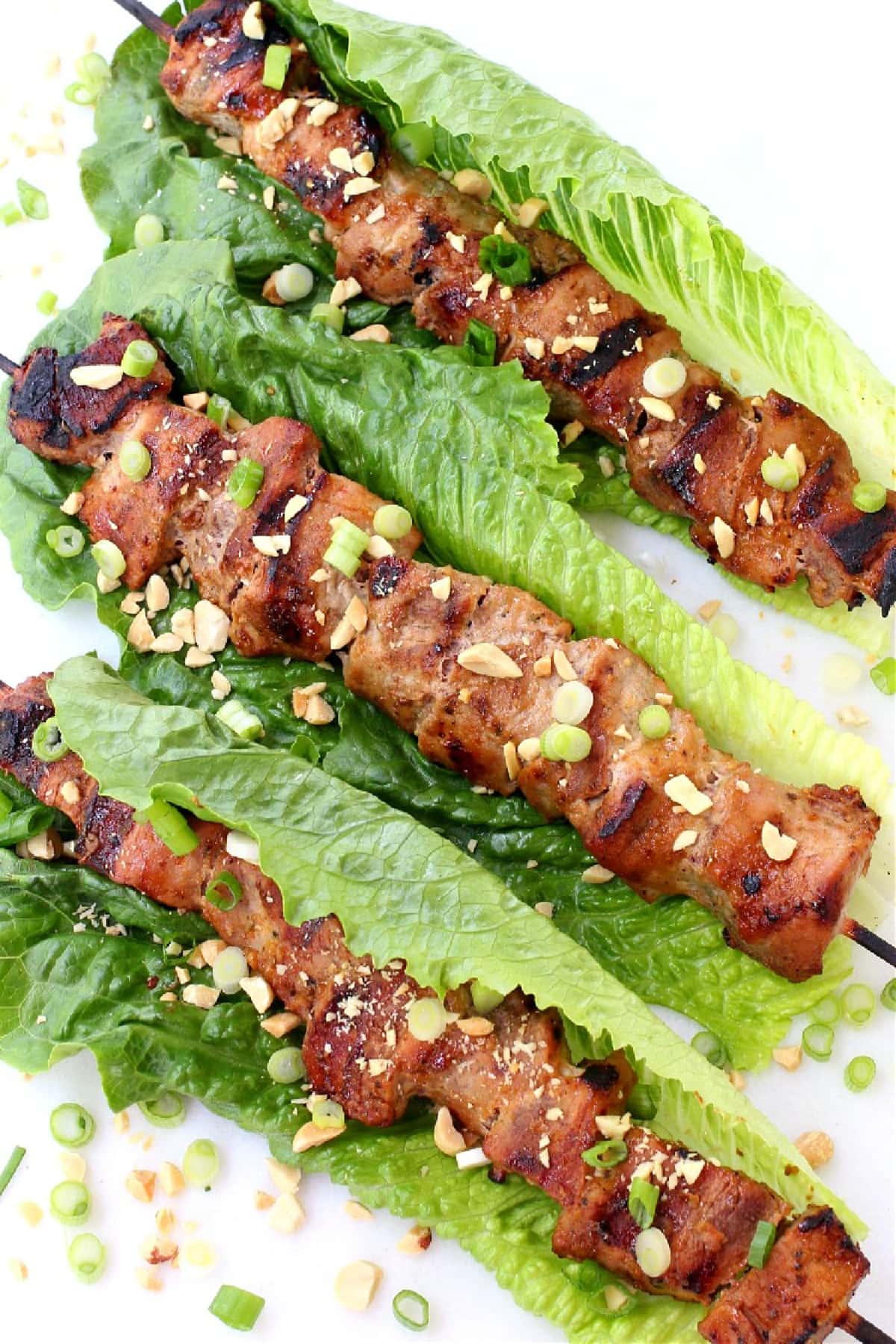 pork kabobs in lettuce leaves with chopped peanuts