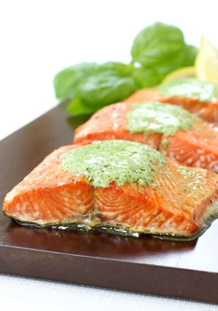 Cedar Plank Salmon with Basil Cream Sauce on a wood surface 