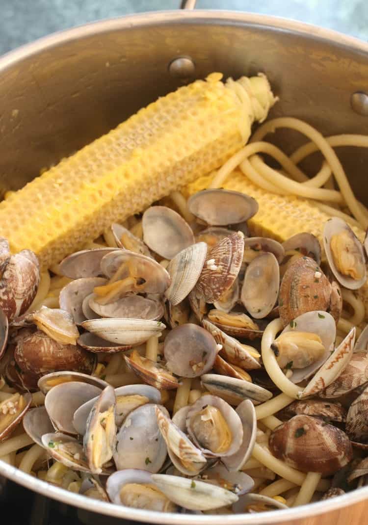 corn on the cob in a pot with clams