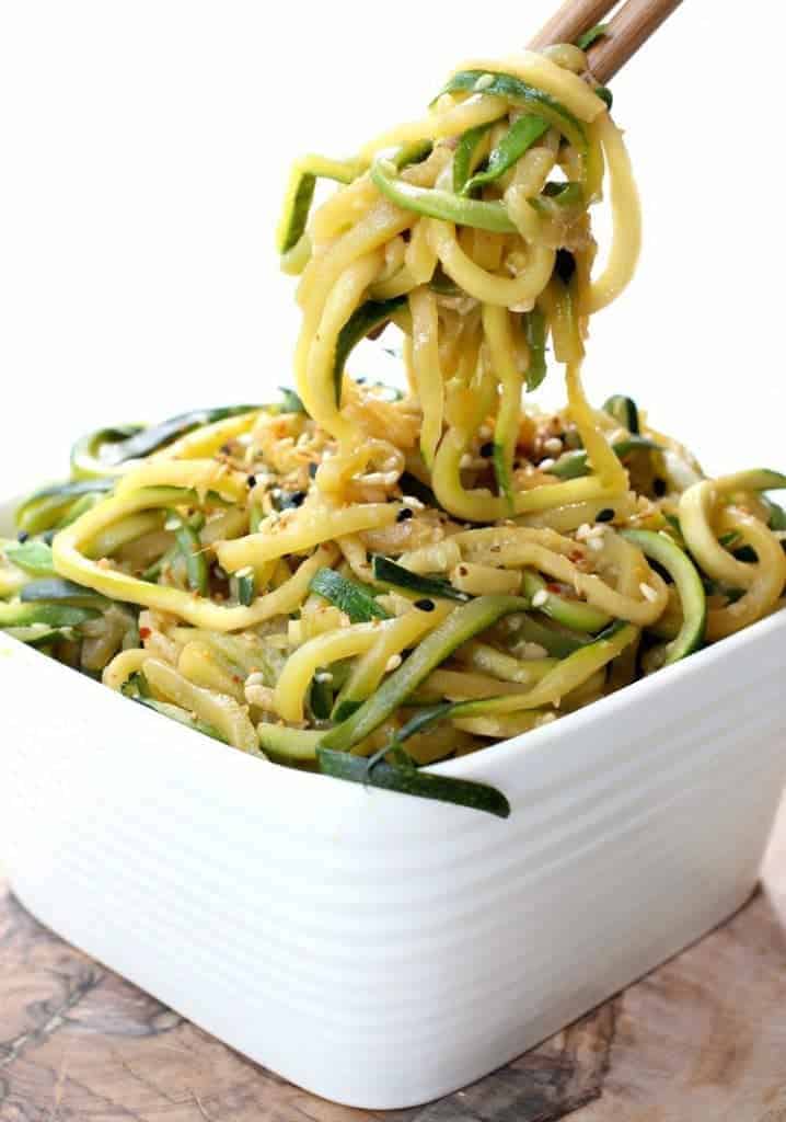 Asian zucchini noodles in a white bowl with chopsticks 