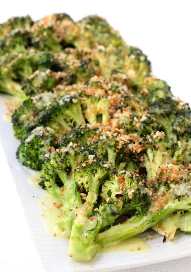 Roasted broccoli on a serving platter with toasted breadcrumbs and sauce