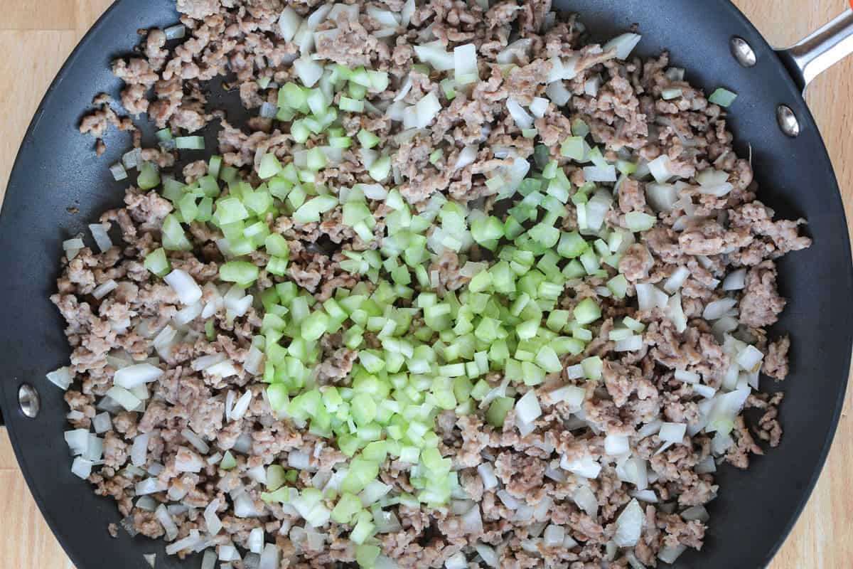 crumbled sausage and celery in a skillet