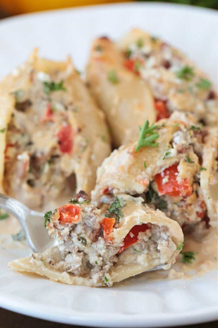 fork on a plate with a bite of cheesesteak stuffed shells