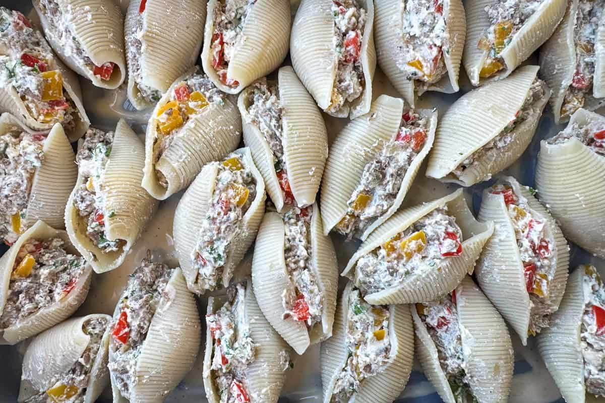 uncooked stuffed shells in baking dish