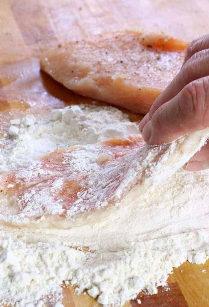 Seared Chicken and Sage Gravy starts with flouring the chicken